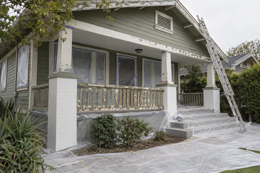 Older Los Angeles bungalow being prepared for lead-safe painting, with plastic on the ground