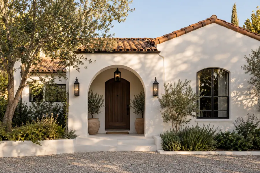Spanish Revival exterior design with smooth stucco, clay tile and an arched entry