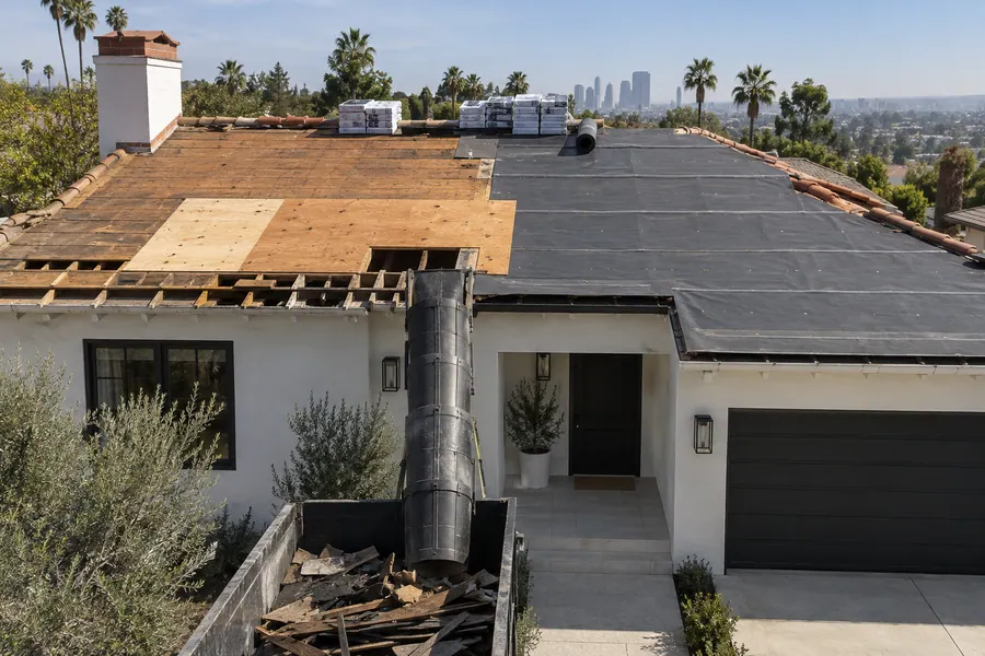 Roof stripped to the deck with new plywood patches and fresh underlayment during a tear-off