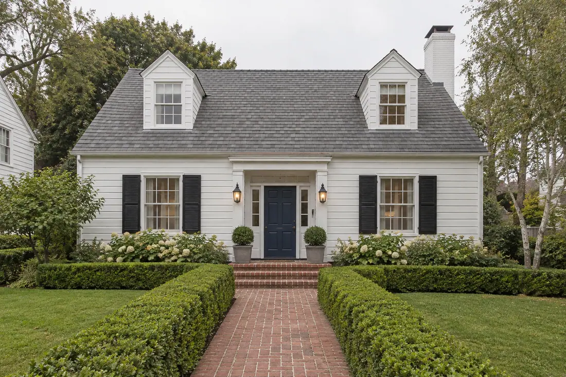Traditional Cape Cod style house in Los Angeles with a steep shingle roof, lap siding and shutters
