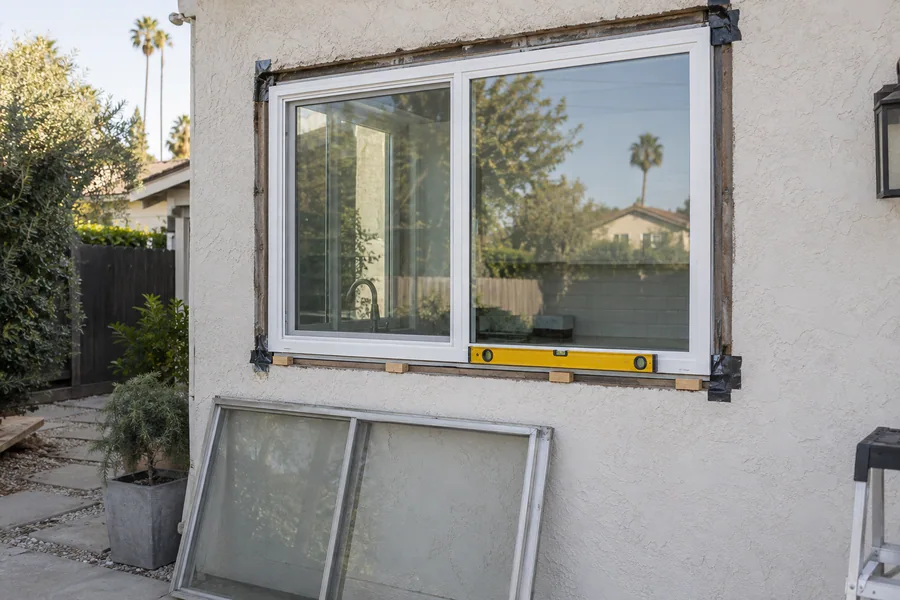 New energy-efficient window being set into a stucco opening on a Los Angeles house
