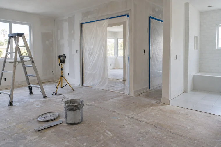 Plastic containment and patched walls in a room being prepped for paint in a Los Angeles house