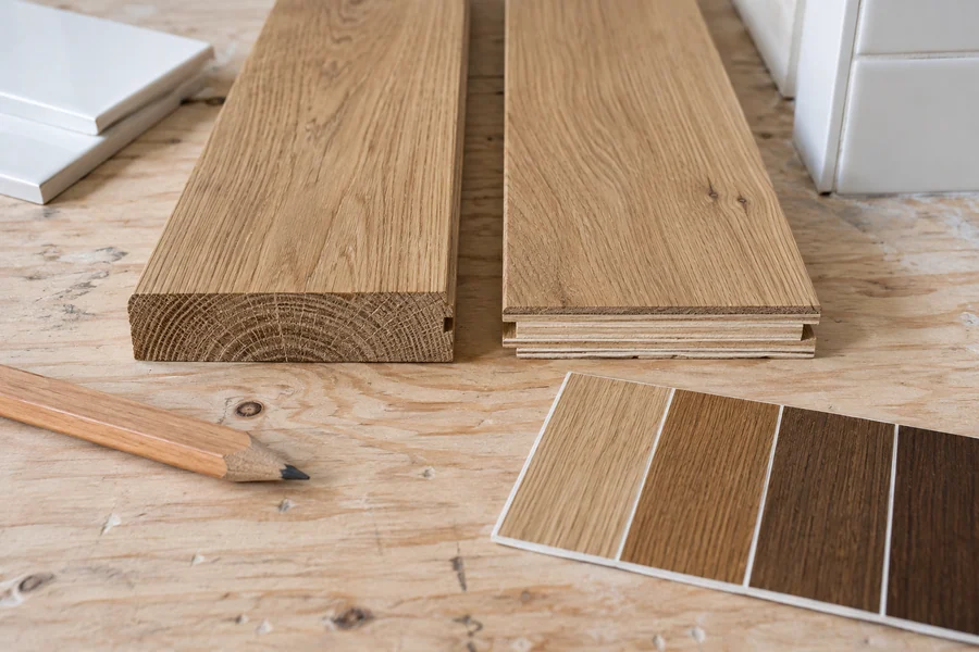 Solid and engineered oak hardwood samples laid side by side on a subfloor