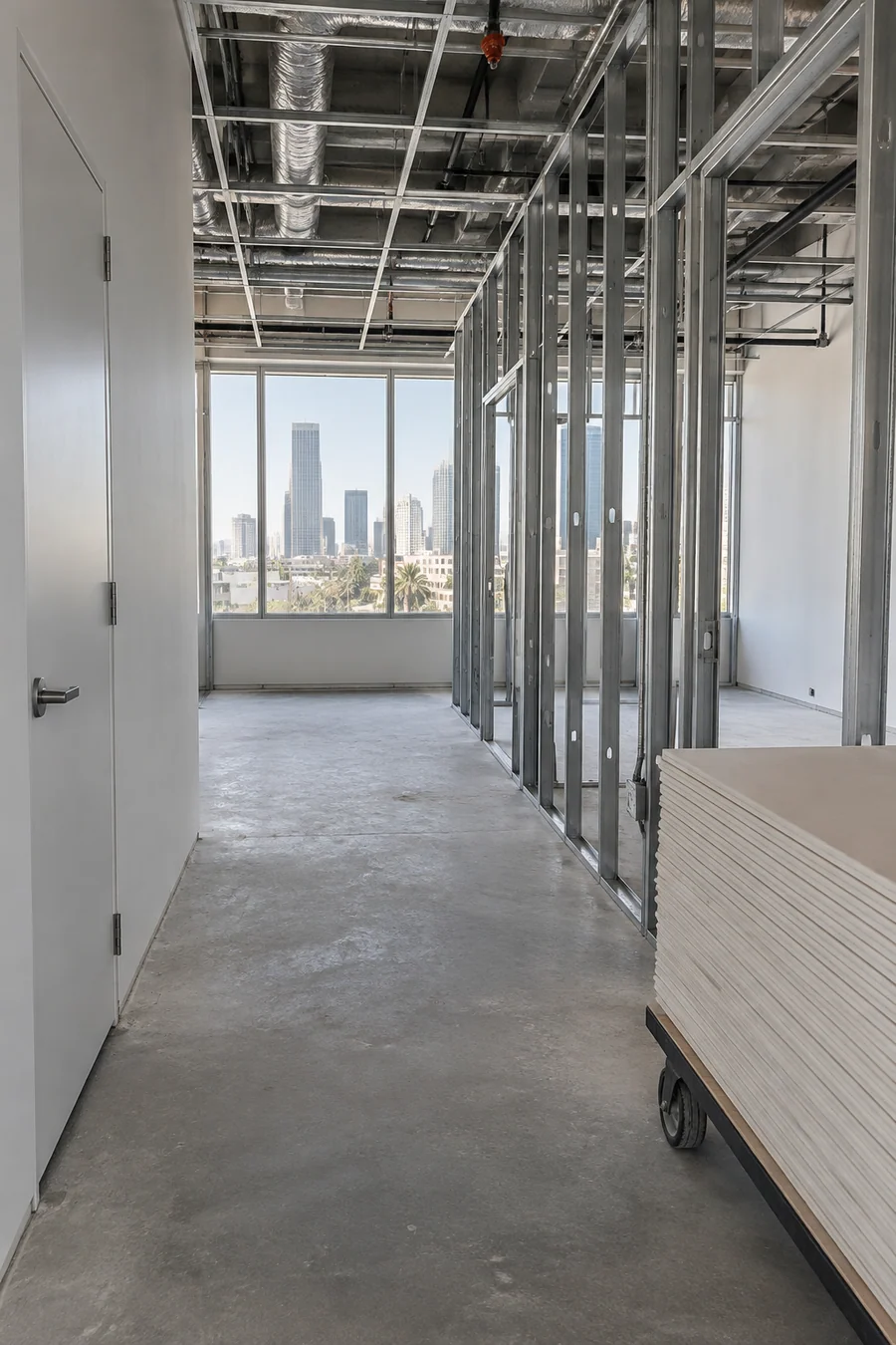 Second-generation office suite midway through a build-out, with old walls kept and new framing added
