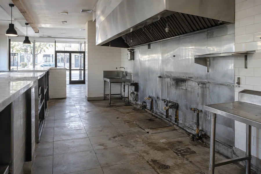 Vacant second-generation restaurant space in Los Angeles with an old hood and an empty kitchen