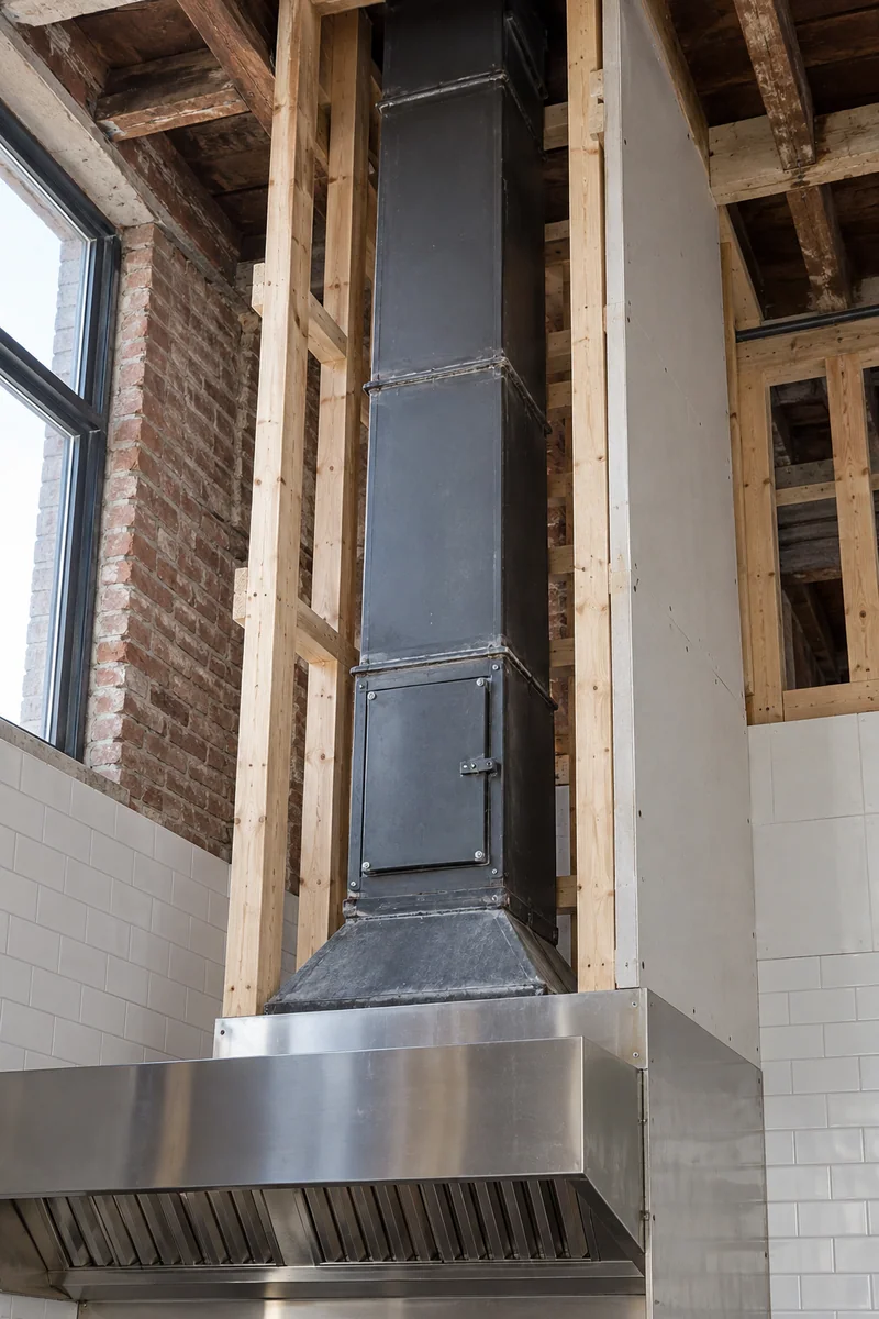 New welded grease duct rising through a framed shaft in an older Whittier, CA restaurant building